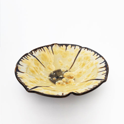 White ceramic decorative bowl with gold crystalline glaze.