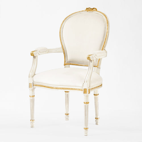 White armchair with gold trim and cream fabric.